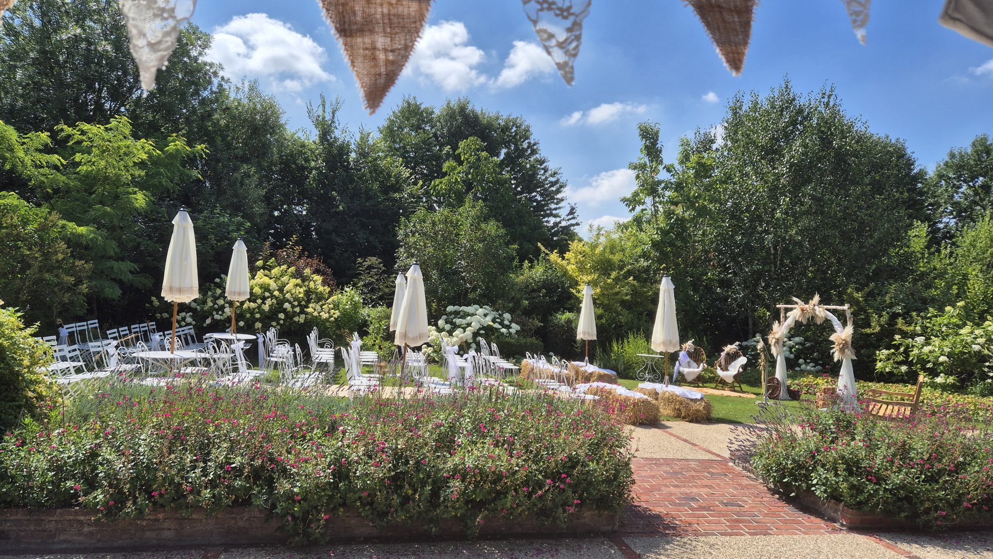 Covered porch decorated for a wedding cocktail with view of the flowered gardens