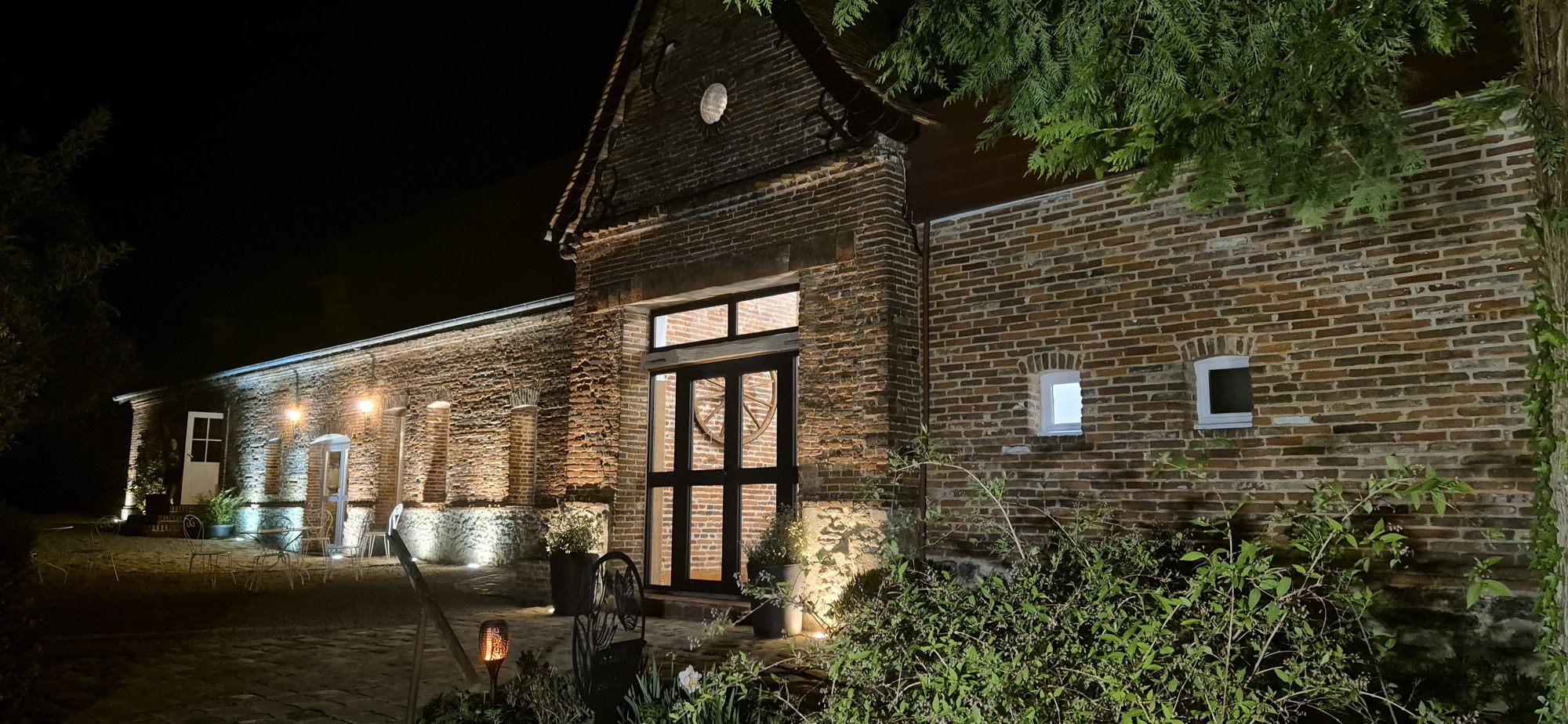 Outdoor reception venue at Cellier du Val Boury in Normandy, view of the cobbled courtyard and covered porch